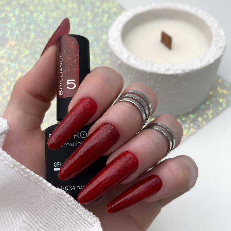 Esmalte en gel Brilliance 05 de DE LA RO en rojo intenso con efecto brillante, aplicado en uñas largas