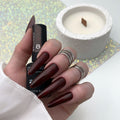 Esmalte en gel Brilliance 08 de DE LA RO en burdeos profundo casi negro con efecto brillante, aplicado en uñas largas
